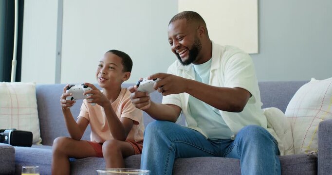 African American father and preteen son with white pads, son talking, father laughing, playing game