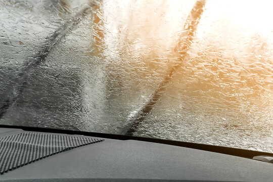 Rear view from inside mirror car,window windshield glass covered with frozen ice layer, nature background at winter cold day