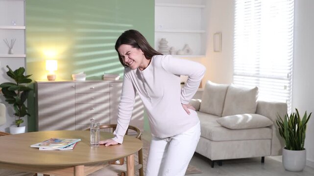 Pregnant woman suffering from pain at home