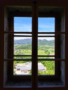 Scenic landscape view framed by a castle window windowpane