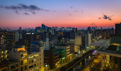 Naklejka premium Vibrant Tokyo city skyline and buildings at sunset in Japan.