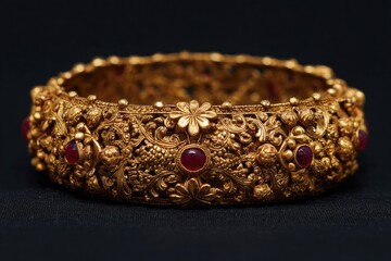 Ornate gold bangle, intricately detailed with floral and leaf patterns, inlaid with ruby