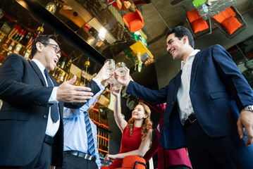 Diverse team of successful business professionals in formal suits celebrating victory and toasting...