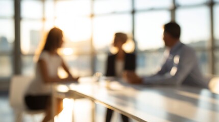 Business professionals meeting, collaborating in a modern office, enjoying bright sunset light through large windows