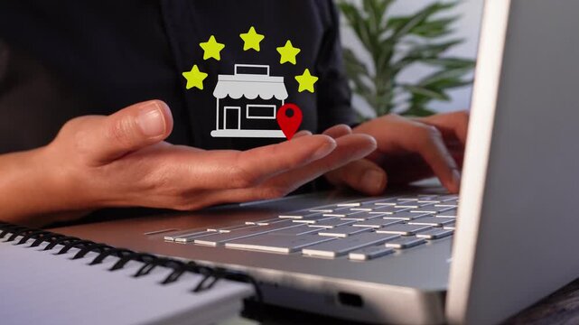 Close-up of a businesswoman's hands working on her laptop while holding an animated five-star rating from a local store.
