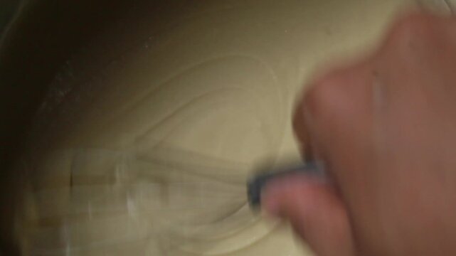 top view of stirring the batter using a whisk