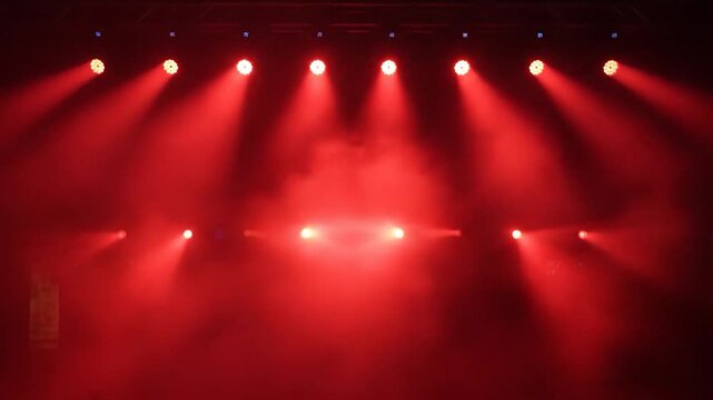 Bright red stage lights illuminate a smoky concert background
