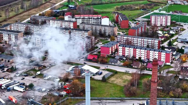 Aerial view of an industrial plant next to a residential area with apartment blocks.