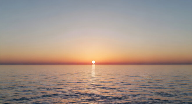 The sun sets low over the tranquil ocean, creating a beautiful serene horizon.