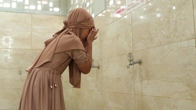 A Muslim girl prepares to pray by performing ablution according to Islamic tradition.