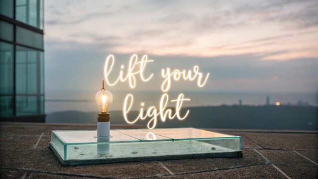 Decorative glass display with a glowing bulb and motivational quote against a scenic sunset background on a rooftop
