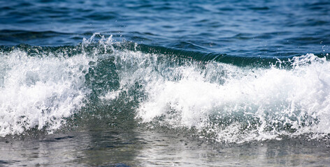 Fototapeta premium Waves ocean texture. Sea waves move. Foamy sea wave with oceanic power. Sea waves in tropical sunshine. Crystal wave reflect light. Sea waves curl and break on the coast.