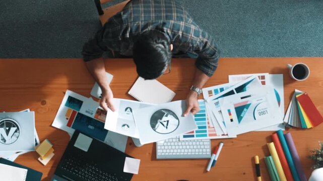 Top view of smart businessman hand choosing color palettes while designing logo graphic. Aerial view of professional interior designer design and select color theme by using color palettes. Symposium.