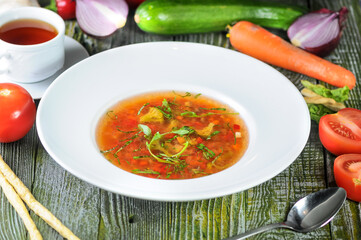 Fresh Tomato Soup with Herbs and Vegetables on a Rustic Wooden Table