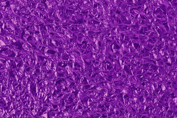 Shiny purple foil texture background, pattern of violet wrapping paper with crumpled and wavy.