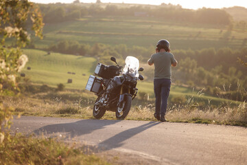 Obraz premium Man and his motorbike in beautiful sunset light.