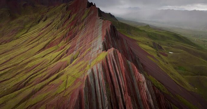 Pallay Punchu Rainbow Mountain near Cusco, Peru, revealing dramatic striped ridgelines and colorful geological layers on mountainous terrain, aerial view
