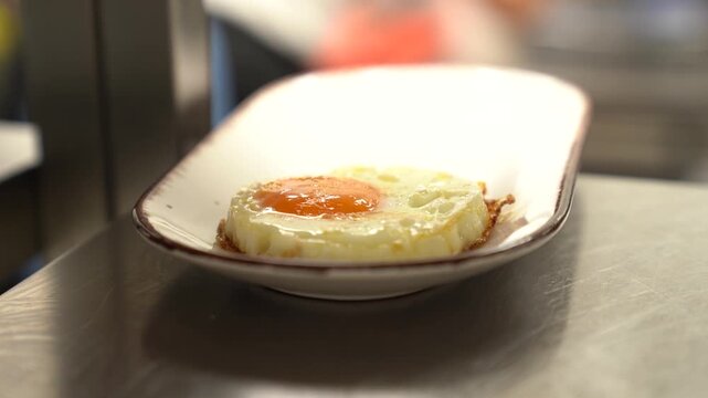 Fried bull's eye egg on white rectangular plate, preparing breakfast, cooking cuisine