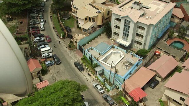 High-angle view of an upscale residential block in Victoria Island, Lagos, Nigeria, featuring a private swimming pool, gated compound and parked cars along a quiet street.