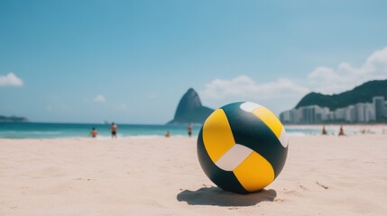 Obraz premium A colorful volleyball rests on a sandy beach with people, blue sky, and distant mountains in the background.