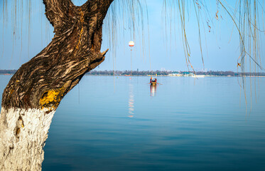 Boat on East Lake Framed by Willow Tree in Wuhan China