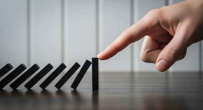Human hand stopping falling dominoes | Concept of risk management and crisis prevention | Business strategy for stopping chain reaction | Symbolic representation of problem solving and intervention