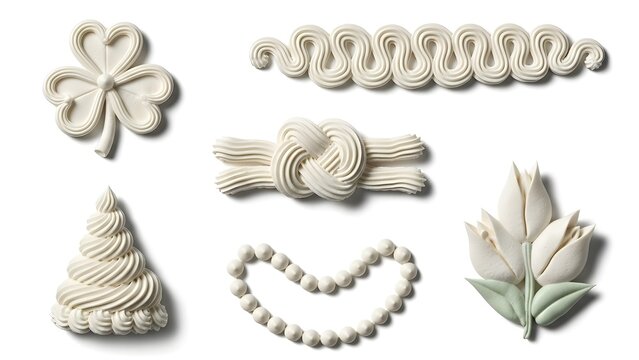 Set of 6 white buttercream piping decorations isolated on a white background. Includes a shamrock, wavy border, knot, Christmas tree, heart-shaped pearl string, and two tulips with green leaves.