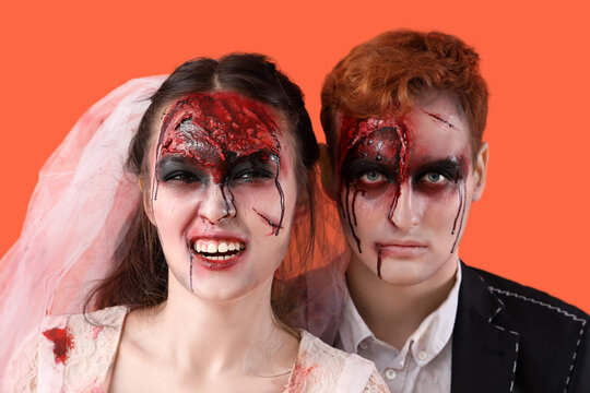 Zombie wedding couple on orange background, closeup