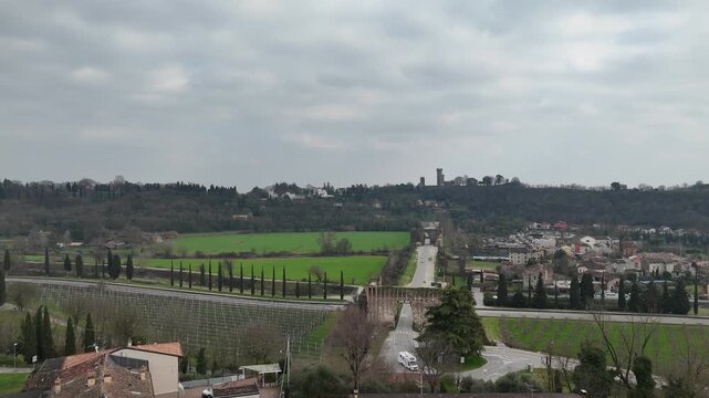 Valeggio sul Mincio with the Visconti Bridge and Borghetto riverside hamlet, showing the Mincio River, weir, historic mills and hillside towers above the town in Veneto, northern Italy