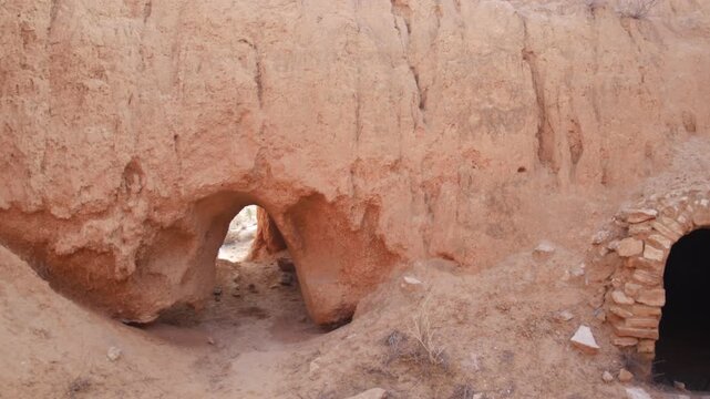 Panorama: Traditional troglodyte houses carved into rock in Matmata, Tunisia. Ancient underground dwellings in arid desert landscape, historic Berber architecture and cultural heritage site