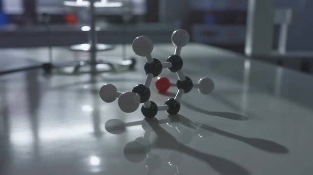 Cinematic close-up of a rotating molecular model displaying a benzene ring on a glossy laboratory table with soft, reflective lighting