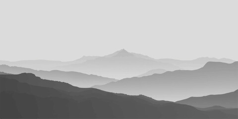 A misty mountain landscape at dawn reveals a silhouette of forest hills under a blue sky as morning fog rolls through the valley during a golden sunrise