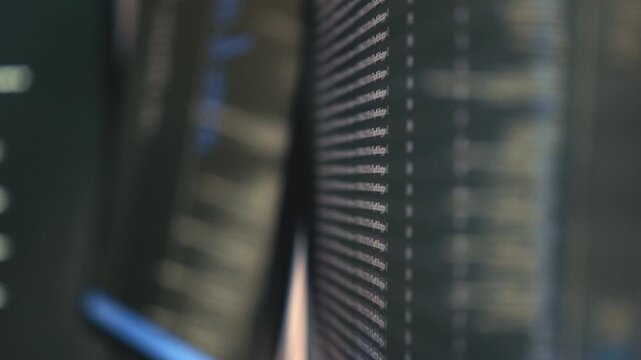Close-up of a computer screen showing lines of code and dotted column guides, resembling a terminal interface with shallow depth of field