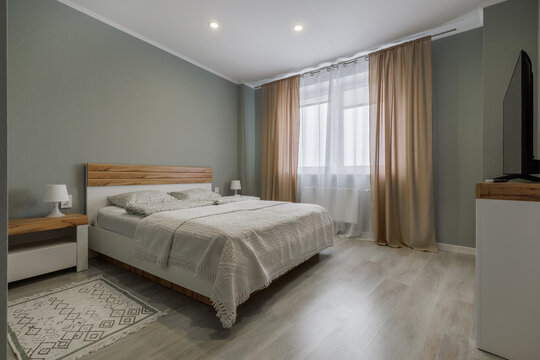 Modern Minimalist Bedroom with Sage Green Walls and Wooden Bed