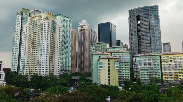 Aerial view approaches Bonifacio Global City skyscrapers beneath clouds, monsoon