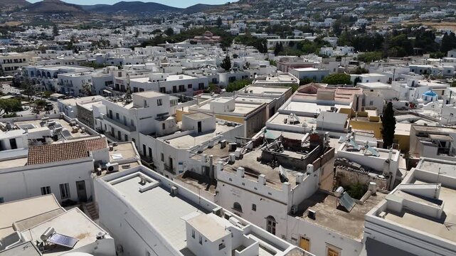 Cyclades,Paros Island,Aerial view circle pan left over old settlement Paroikia with unique Cycladic architecture towards the sea and the Bay on a sunny day.