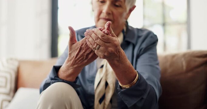 Sore, hands and senior woman in lounge, discomfort and pensioner with muscle tension or pain in home. Massage, joint strain and symptoms for arthritis in house, hurt and elderly person with injury