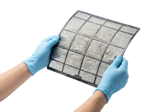 Hands in blue gloves holding a dirty air conditioner filter against a white background, showing accumulated dust and grime