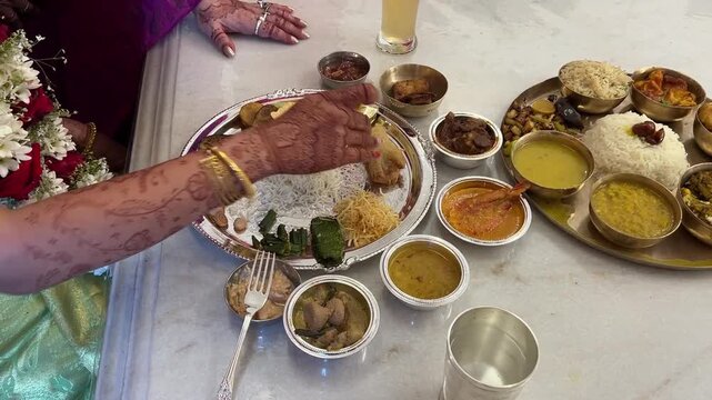 Bengali bride eating Aiburobhat thali prepared for the wedding in India
