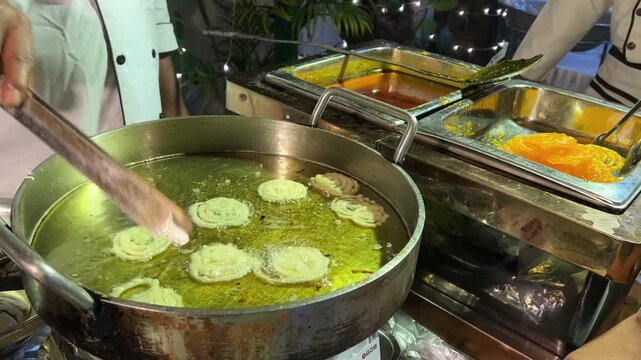 Deep frying jalebi in a live food counter in a wedding in India