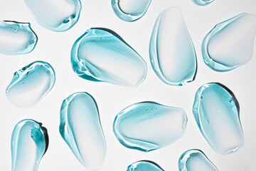 Pure blue transparent cosmetic gel smears on white background, skin care glycerin texture. top view
