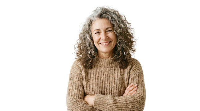 Smiling woman with curly hair wearing a light brown sweater crossing her arms in a bright setting no background