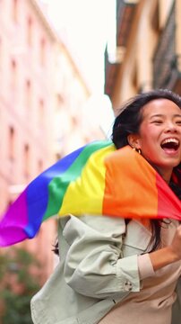 Lesbian couple walking with a rainbow flag on pride day