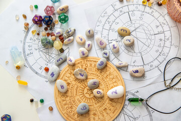 Numerology stones with numbers on wooden zodiac wheel and natal charts background