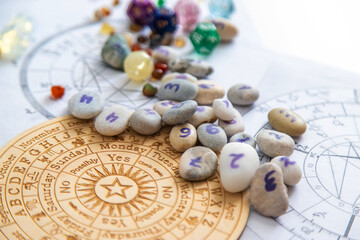 Numerology stones with numbers on wooden zodiac wheel and natal charts background