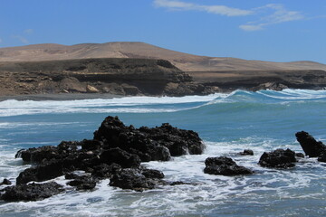 Obraz premium Turquoise Waves Breaking on Black Volcanic Rocks Fuerteventura