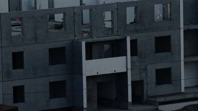 Exterior view multi-level concrete shell apartment building development. Raw construction materials exposed structure create stark, modern architectural landscape.