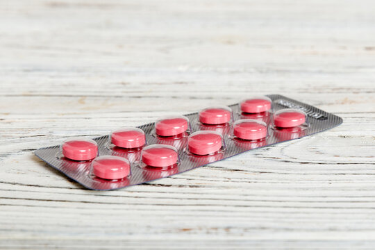 Blister package with Vitamin on color background. Medicine pills on a light background. Medicines and prescription pills flat lay background. pink medical tablets in blister
