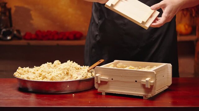 Workers are using machinery to make fermented soybean paste.