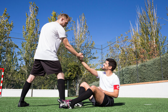 Football player helping an injured player during a match